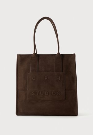 Sac cabas en cuir marron foncé avec deux poignées et une poche avant embossée du texte "CPH STUDIOS".