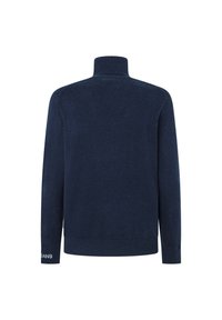 Tumši zilas krāsas augsta apkakle džemperis, izgatavots no mīksta adījuma materiāla. Tam ir garas piedurknes un ribotas aproces, kā arī diskrēta logo detaļa uz piedurknes.