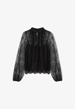 Blouse en dentelle noire avec un col haut, des manches longues transparentes et une coupe décontractée. Présente des motifs en dentelle complexes et un ourlet festonné.