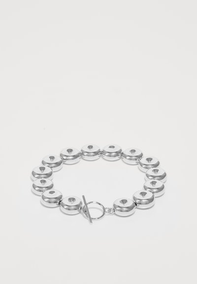 Bracciale d'argento con anelli rotondi a forma di disco con una finitura lucida e una chiusura a gancio, che mette in mostra una texture liscia e riflettente.