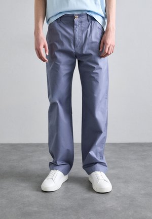 Light blue cotton-blend trousers with a relaxed fit, featuring a button closure, side pockets, and a smooth texture. Worn with white sneakers.
