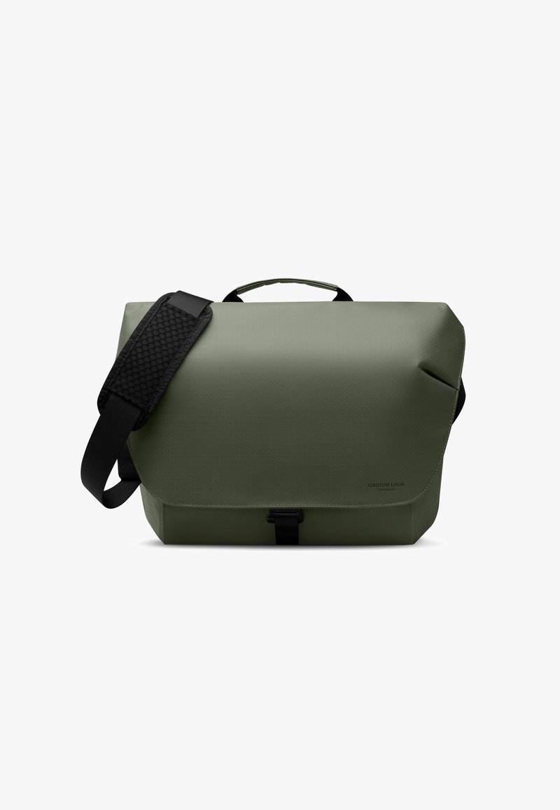 Sac messager rectangulaire vert olive avec bandoulière noire réglable et poignée supérieure, rabat avant sécurisé par une boucle noire.