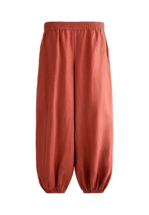Løse linnedbukser i rustfarve med elastisk talje og elastiske, opsamlede manchetter samt sidelommer.