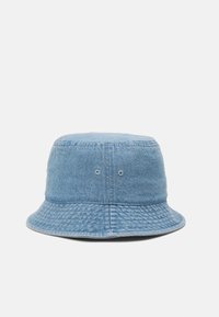 Blue denim bucket hat with vertical texture, wide brim, and two ventilation eyelets on the side. Simple, unadorned design.
