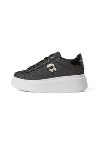 Czarne sportowe buty z brokatem, z masywną białą podeszwą, wyposażone w wyraźne logo kreskówkowe po boku oraz okrągłe sznurowadła. Gładka, teksturowana powierzchnia.