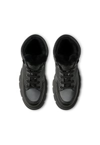 Botas de cuero negro con un collar acolchado, suela de goma gruesa y cordones negros. Interior forrado con material suave negro para mayor comodidad.