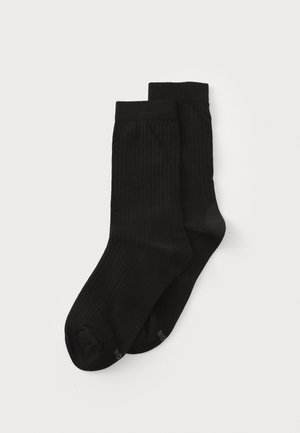 Black ribbed socks made of soft material, featuring a snug fit and reinforced toe, designed for comfort and durability.