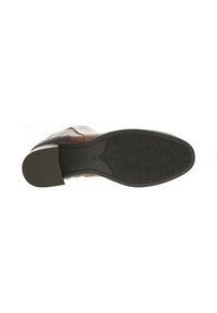 Semelle en cuir marron d'une chaussure habillée avec un fond en caoutchouc noir texturé et un petit talon, présentant une finition lisse et un design minimaliste.