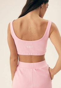 Różowy, dopasowany top crop z szerokim dekoltem, wykonany z miękkiego materiału. Posiada logo na plecach oraz rypsowy dół dla pewnego dopasowania.