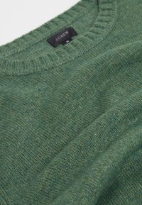 Grüner Strickpullover mit Rundhalsausschnitt aus strukturiertem Stoff. Sichtbares Etikett mit der Aufschrift "J.Crew" und Größe "M" angebracht.