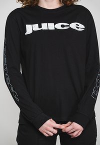 Black long-sleeve t-shirt made from cotton, featuring bold white text "juice" across the chest and "respect." on the sleeves.