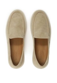 Bež močvirni čevlji za natikanje z obloženim podplatom, okroglim prstom in gladkim, oblazinjenim notranjim vložkom. Na notranjem vložku vtisnjen logotip, mehka tekstura.