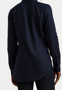 Marinblå långärmad skjorta i ett lätt tyg med rak passform, knäppta manschetter och en yoke-detalj på ryggen.