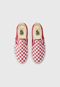 Zapatillas de lona de cuadros rojos y blancos tipo slip-on, con una parte superior de lona y suela de goma blanca. Presentan un lado elástico para poner y quitar fácilmente. Marca mínima.