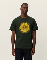 Tmavozelené bavlnené tričko s žltým kruhovým grafickým motívom a textom "LES DEUX COPENHAGEN" a "INŠPIROVANÉ KOMUNITOU, VEDENÉ PÁLENÍM."