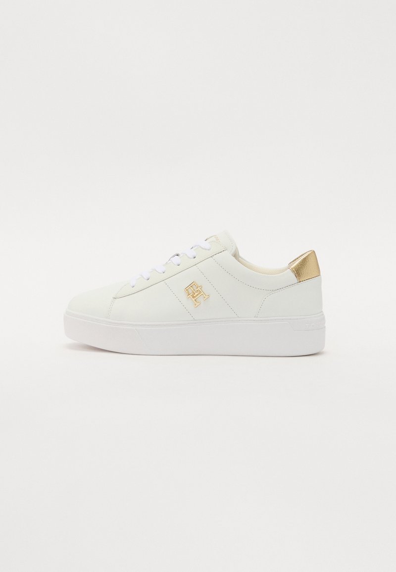 Baskets en cuir blanc avec talon orné d'un accent doré, semelle en caoutchouc blanche et logo doré sur le côté. Caractérisées par un bout rond et un système de laçage.