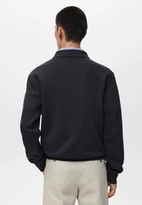 Sudadera de un oscuro color azul marino con cuello, mangas largas y un ajuste relajado. Vista trasera que muestra una tela suave y un diseño minimalista.