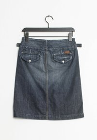 Falda de mezclilla, azul oscuro, de longitud media; presenta dos bolsillos traseros con botones metálicos, detalle de costura y una textura suave. Se cuelga de un gancho negro.