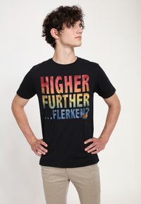 Czarny bawełniany t-shirt z odważnym tekstem w gradientzie w kolorach czerwonym, żółtym i niebieskim: "WYŻEJ DALEJ ...FLEKEN?" z małą grafiką kota.