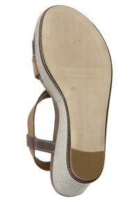 Sandale en cuir marron et tissu beige avec une semelle en caoutchouc texturé, présentant un léger talon et un logo de la marque embossé près de l'orteil.