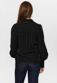 Black blouse with subtle vertical stripes, puffed sleeves, and textured cuffs. Features a round neckline and a straight hemline.