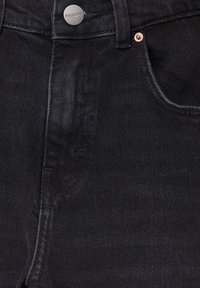 Jean en denim noir vu de face avec un bouton en métal gravé "PULL&BEAR" et une poche visible avec rivet sur le côté droit.