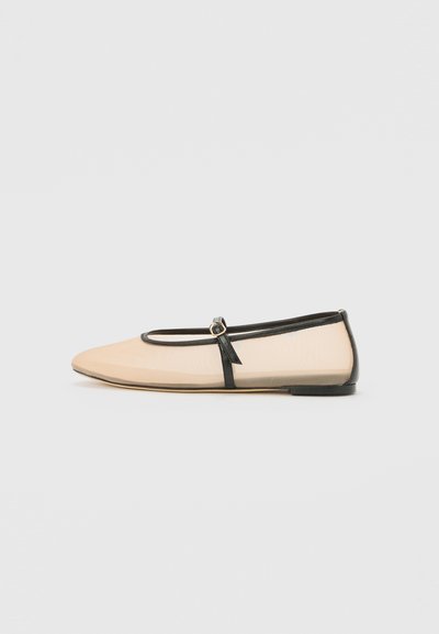 Beige ballet flat with black accents, featuring a round toe, thin black strap with a small gold circle detail, and a smooth texture.
