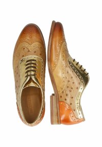 Beige und goldene Lederschuhe mit Broguemuster, glatter Oberfläche, runder Zehenform und kontrastierenden orangefarbenen Absatzakzenten.
