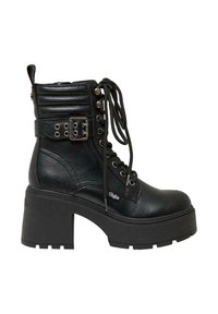Stivale alla caviglia in pelle nera con zeppa chunky, lacci frontali, accenti metallici, colletto imbottito e cinturino decorativo con fibbia.