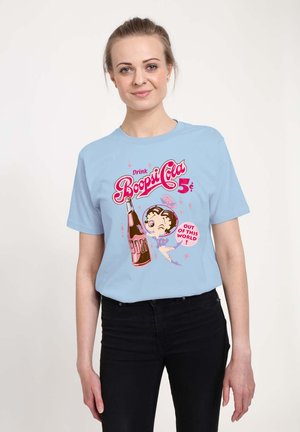Lyseblå kortærmet t-shirt med et farverigt grafik af en sodavandsflaske og en tegneseriefigur, med teksten "Drik Boopsi Cola 5¢".