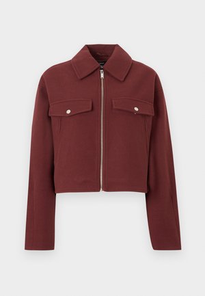 Burgundy cropped jacket made from a textured fabric. Features a zip closure and two front pockets with silver snap buttons.