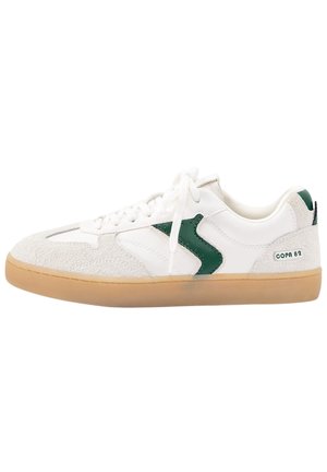 Weißer und beiger Sneaker mit grünem Logodetail, Gummisohle, weißen Schnürsenkeln und "COPA 82" Schriftzug an der Fersenseite.