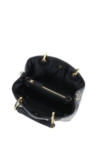 Borsa a righe bianche e nere con hardware dorato, con esterno testurizzato e interno foderato in tessuto dotato di tasca con cerniera.