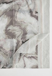 Schichtstoff mit einer welligen Textur, versehen mit einem hellgrauen und rosafarbenen abstrakten Muster sowie subtilen glänzenden Akzenten, teilweise an einer Ecke gefaltet.