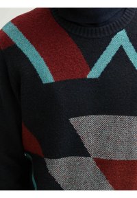 Gebreide trui met een marineblauwe basis en geometrische patronen in rood, teal en grijs. Zachte textuur met een geribbelde halsafwerking.