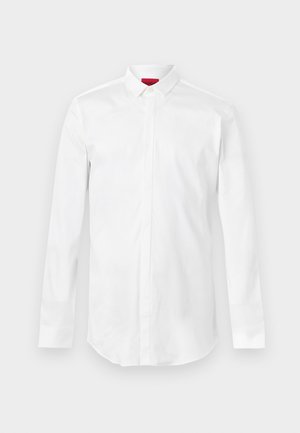 Fehér hosszú ujjú ing hegyes gallérral és rejtett gombos patenttal, sima világos háttéren bemutatva.