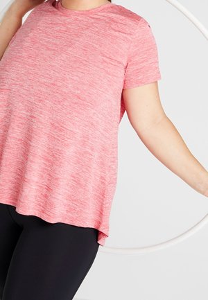 Persona che indossa una maglietta a maniche corte rosa mélange e leggings neri, che tiene un hula hoop bianco contro uno sfondo chiaro.