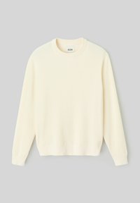 Pull crème à côtes avec un col rond, des manches longues et un ourlet droit. Fabriqué en tissu doux, comportant une texture subtile sur l'ensemble.