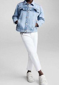 Světlomodrá džínová bunda s volánky, zapínáním na knoflíky a postranními kapsami, doplněná o bílé zkrácené džíny a bílé tenisky.