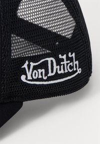 Fekete trucker sapka hálós hátsó résszel és fehér hímzett "Von Dutch" logóval. A sapka kerek napernyővel és strukturált kialakítással rendelkezik.