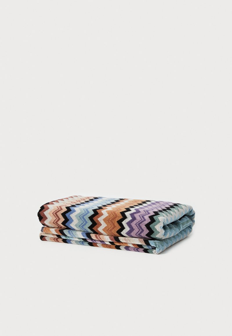 Coperta multicolore con motivo a zigzag, in tonalità di blu, arancione, viola e nero, realizzata in un morbido materiale tessile.