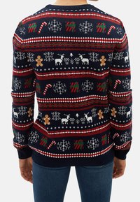 Navy blue knit sweater featuring festive patterns, including snowflakes, reindeer, candy canes, and gingerbread men in red, white, and green.