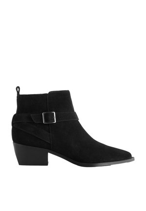Black suede ankle boot with low block heel and side strap featuring a silver buckle, pointed toe, and pull tab at the back.