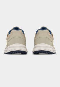 Μπεζ αθλητικά παπούτσια με υφασμένο πάνω μέρος, γαλάζιες λεπτομέρειες, λευκή μεσαία σόλα και μαύρη λαστιχένια εξωτερική σόλα με ανάγλυφο σχέδιο.