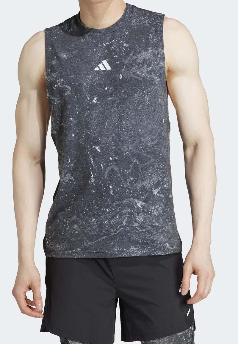 Bezramenné sportovní tričko v černé barvě s šedým mramorovým vzorem, s logem Adidas. Vyrobeno z lehké, strukturované látky pro aktivní nošení.