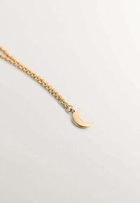 Collar de cadena de oro con un colgante de luna creciente. La cadena tiene eslabones ovalados interconectados, mientras que el colgante es liso y brillante.