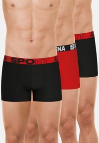 Trois paires de maillots de sport en noir et rouge, avec des ceintures élastiques portant la marque "SPORT". Le tissu semble lisse et ajusté.