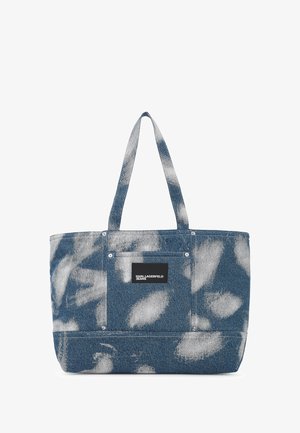 Džínová taška v modrej farbe s jemným abstraktným vzorom. Obsahuje pevné ramenné popruhy a čierny logový nášivok na prednej strane.