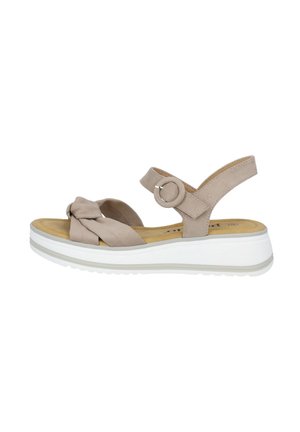 Sandal beige con design a tracolla intrecciata, cinturino alla caviglia con hardware circolare e suola piatta bianca. Materiale in morbido suede e punta rotonda.