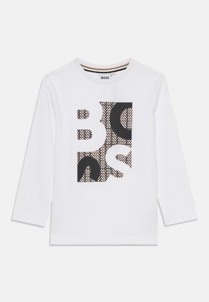 Chemise blanche à manches longues avec un motif graphique noir et marron, comportant des lettres en gras. Design col rond, en coton.